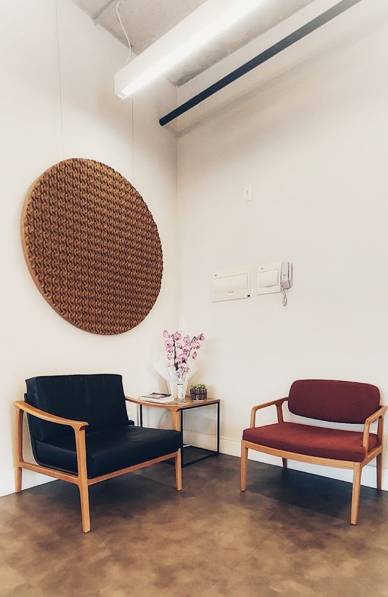 Recepção do estúdio com poltronas e painel de madeira